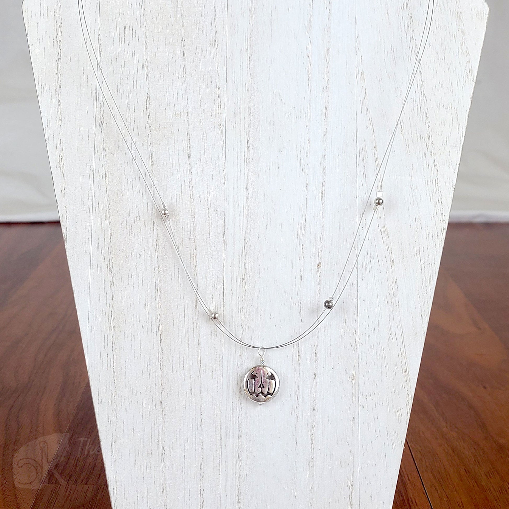 Tigertail necklace with simple round beads and jack o'lantern charms in antique silver