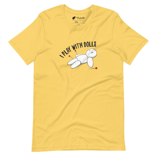 Yellow t-shirt with graphic of white voodoo doll with Xs for eyes stuck with several pins and text "I PLAY WITH DOLLS"