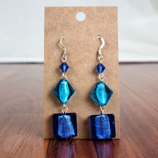 Tiered earrings made with blue and aqua foil glass and faceted crystal beads on silver fittings.