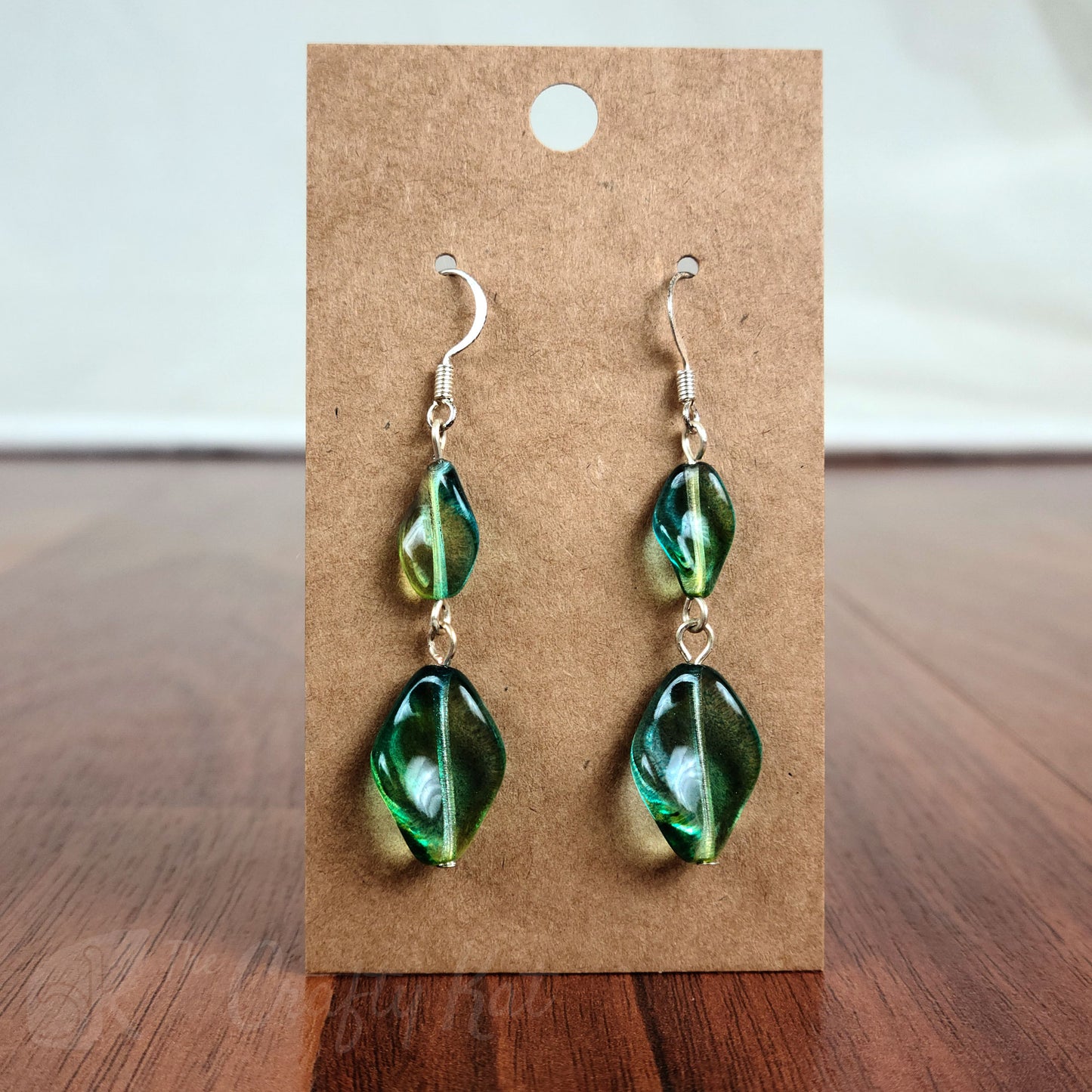 Tiered earrings made with translucent green twisted glass beads on silver fittings.