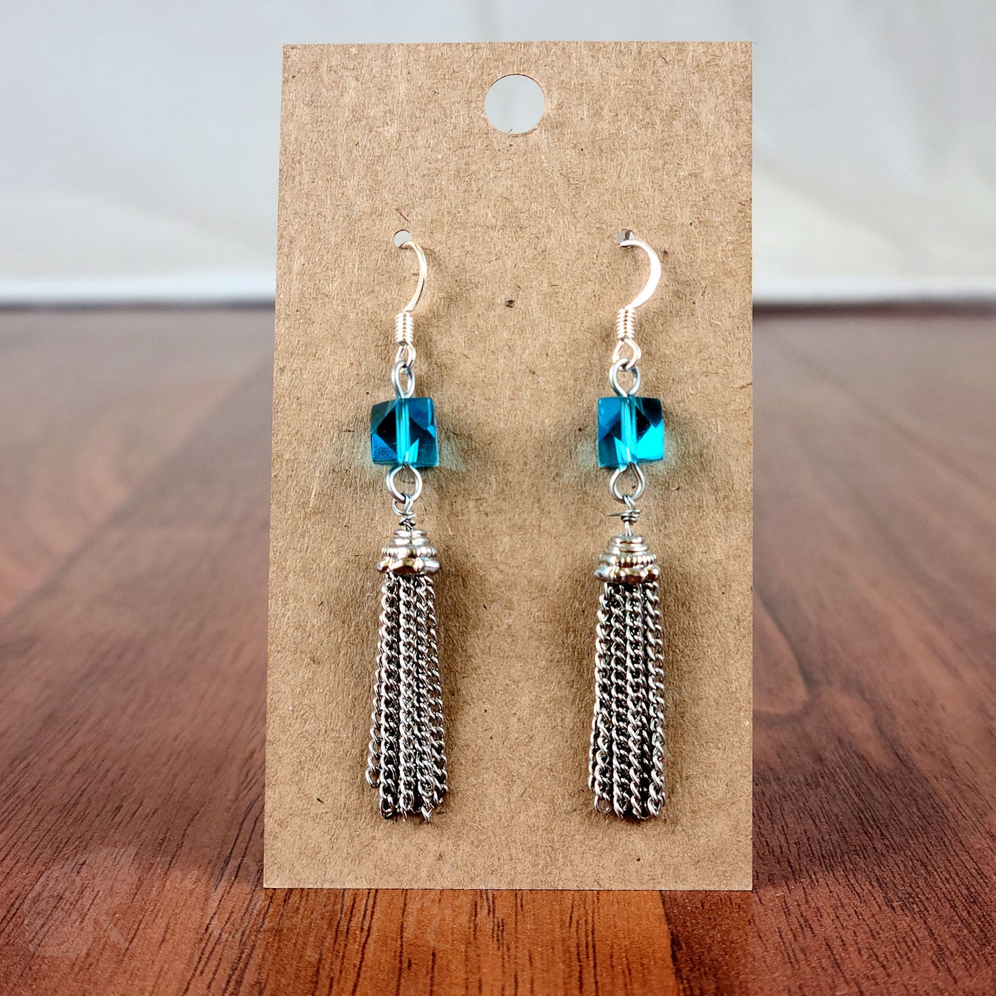 Drop earring featuring a cyan angle-cut cube crystal bead and silver chain tassle and fittings