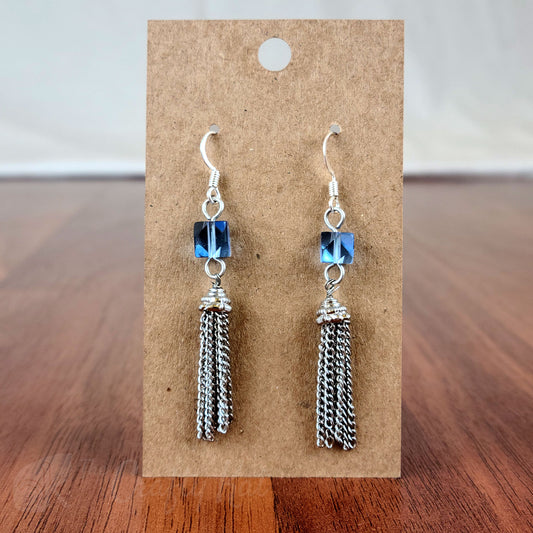 Drop earring featuring an ice blue angle-cut cube crystal bead and silver chain tassle and fittings