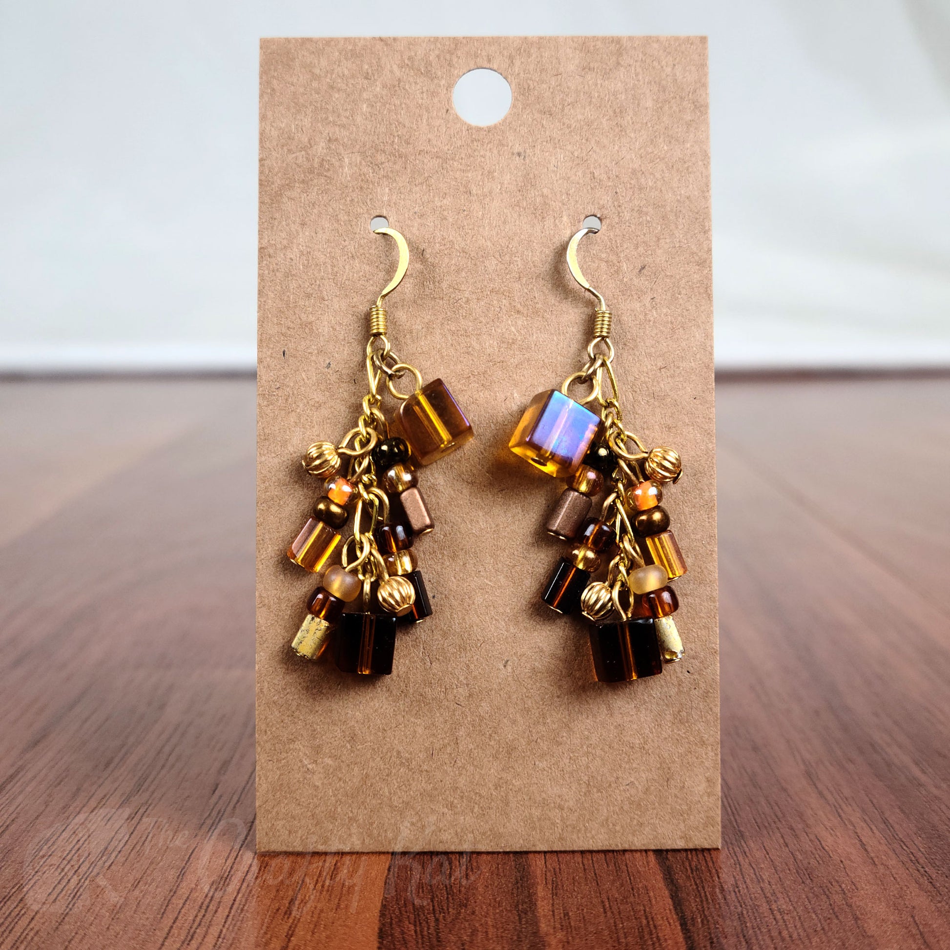 Cascading earrings made of gold, amber, and brown glass beads with gold beads and fittings