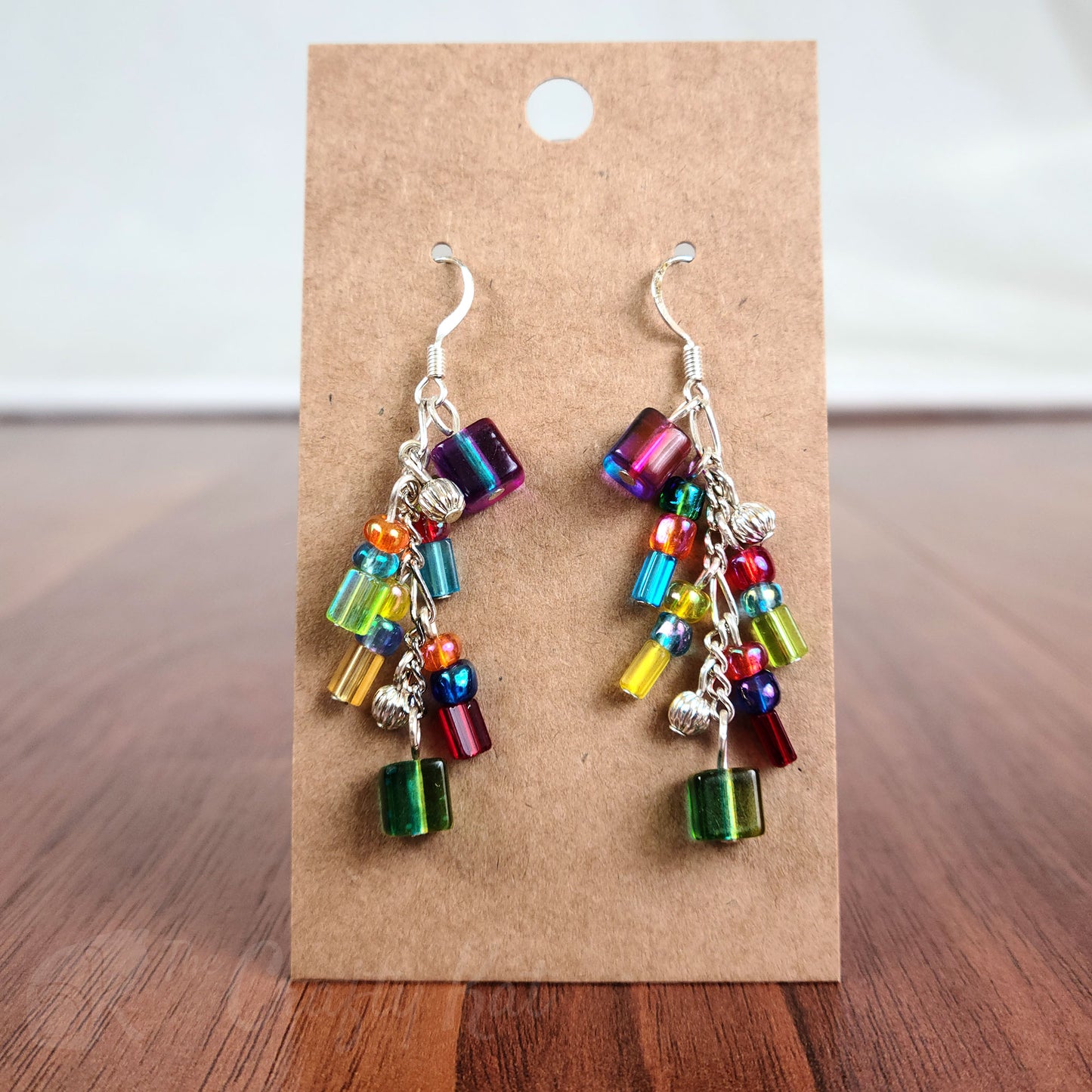 Cascading earrings made of green, red, blue, purple, pink, and orange pressed glass beads with silver beads and fittings