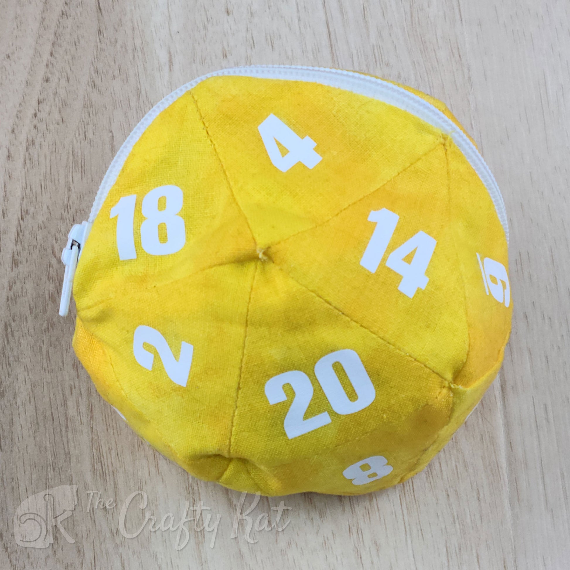 A zippered cotton pouch in the shape of a twenty-sided die, commonly referred to as a d20. The bag shown is yellow with white numbers.