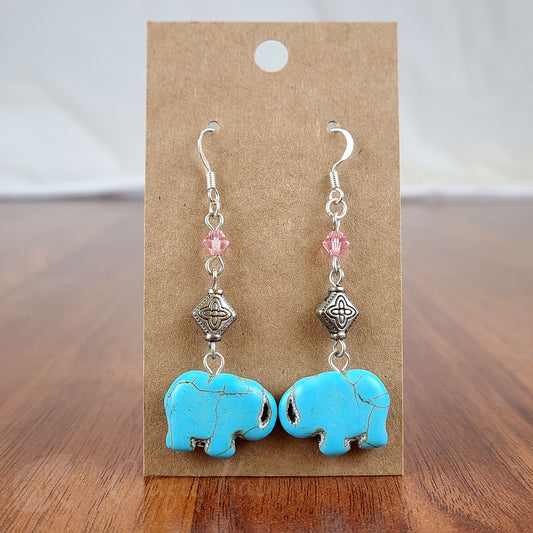 Tiered earrings featuring turquoise-dyed stone cut into the shapes of elephants, crystal bicone beads, and silver-plated metal beads and fittings