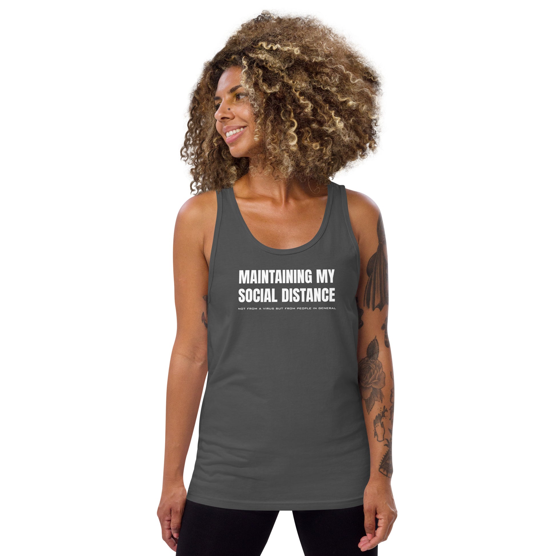 Model wearing an Asphalt (dark gray) unisex tank top with white graphic: "MAINTAINING MY SOCIAL DISTANCE not from a virus but from people in general"