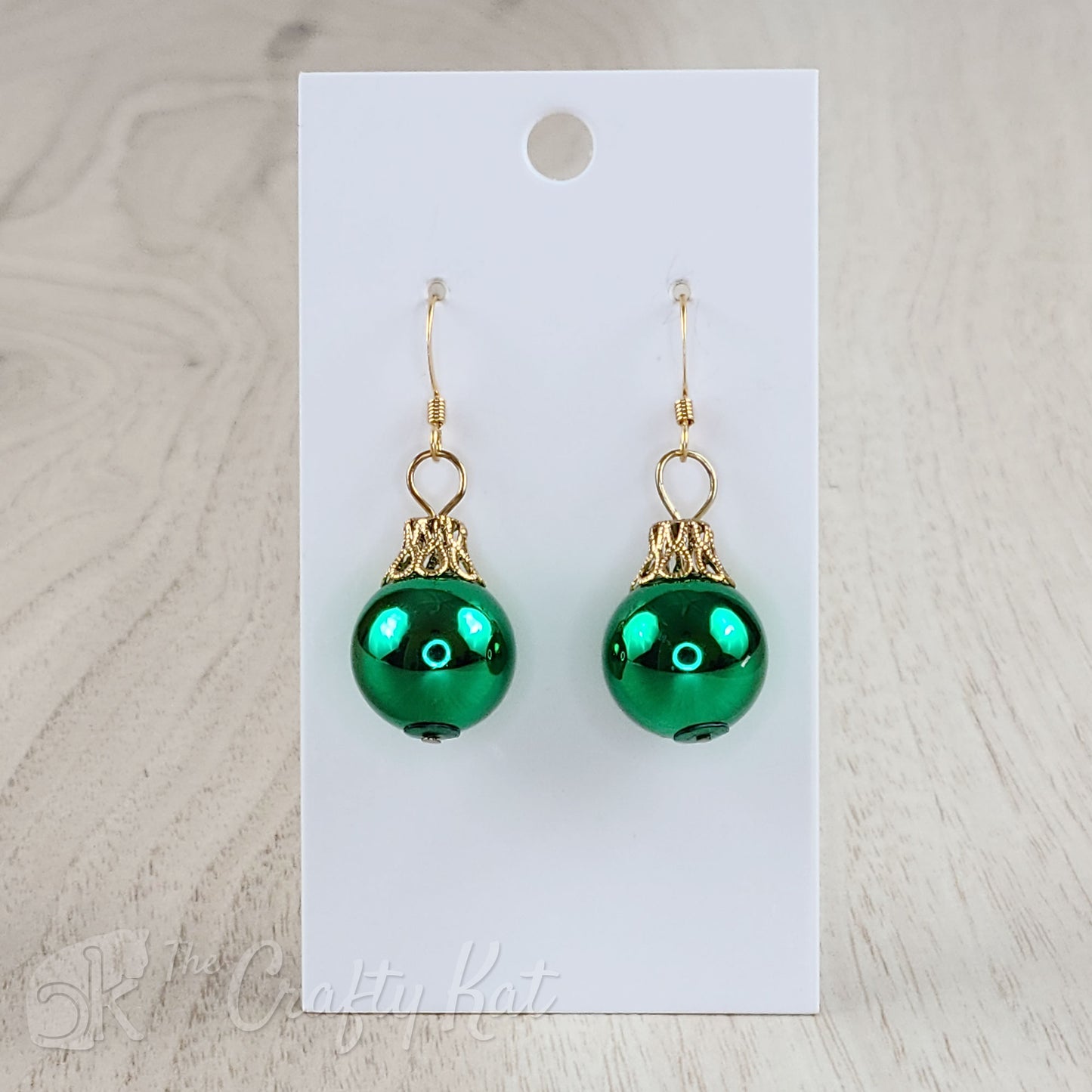 Each earring is a green globe with a gold-plated filigree cap, giving each the appearance of a classic holiday tree ornament.