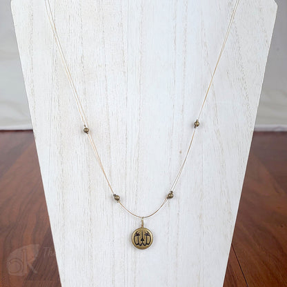 Tigertail necklace with simple round beads and jack o'lantern charms in antique gold