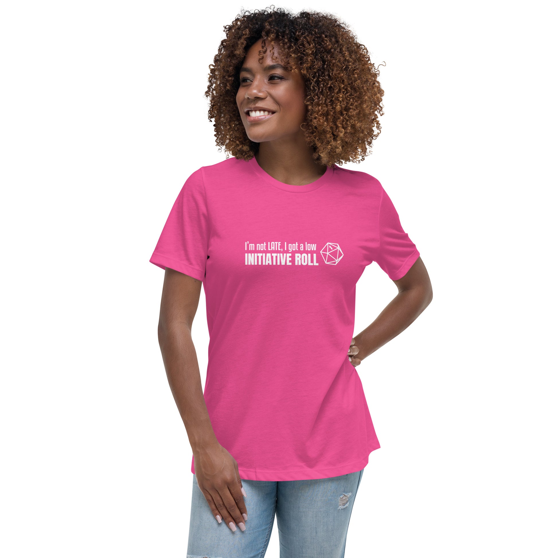 Female model wearing Berry (magenta) women's relaxed-fit t-shirt with a graphic of a d20 (twenty-sided die) showing a roll of "1" and text: "I'm not LATE, I got a low INITIATIVE ROLL"