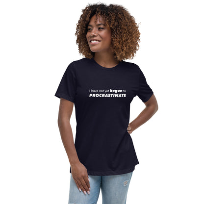 Female model wearing navy women's relaxed-fit t-shirt with text graphic: "I have not yet BEGUN to PROCRASTINATE"