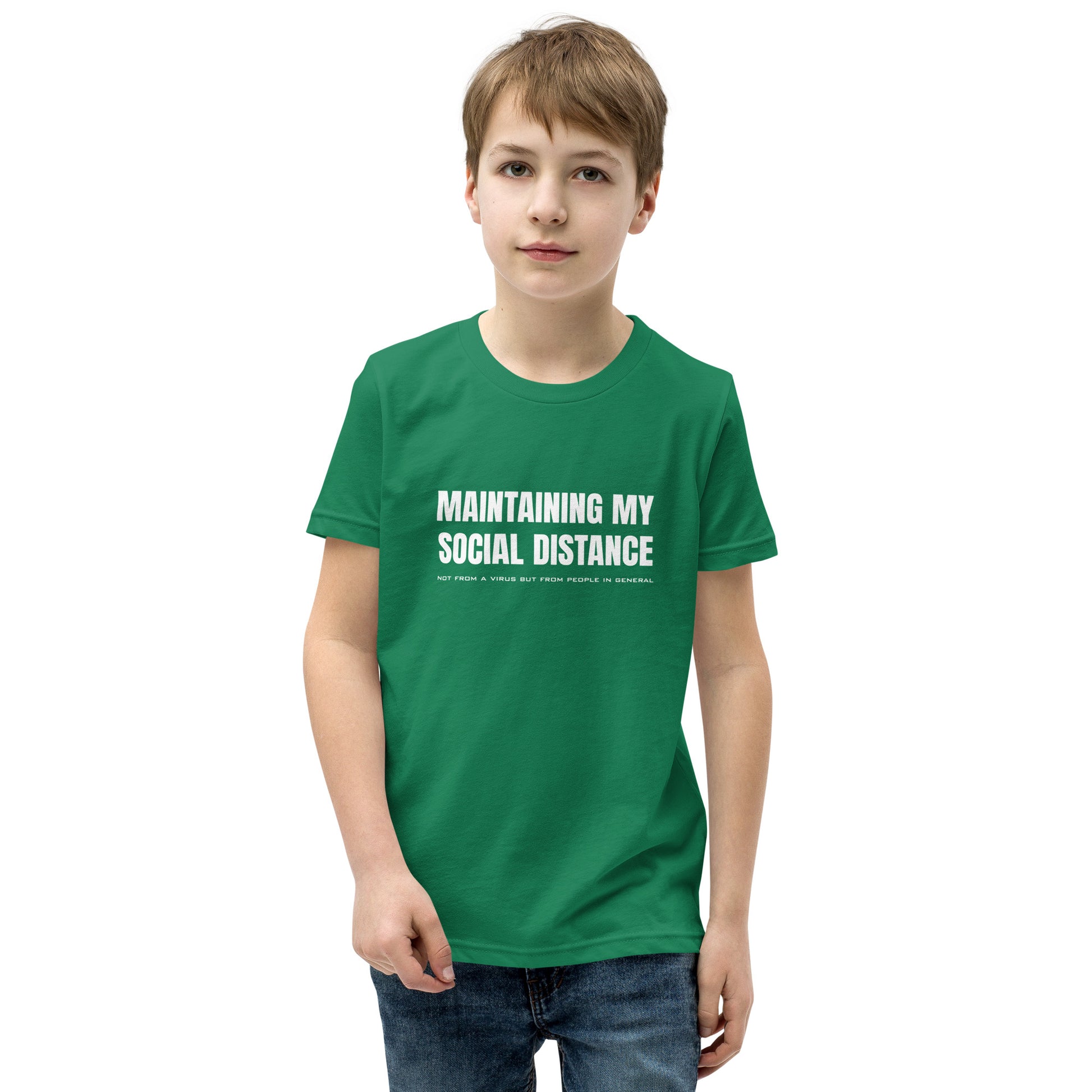 Model wearing Kelly green youth t-shirt with white graphic: "MAINTAINING MY SOCIAL DISTANCE not from a virus but from people in general"